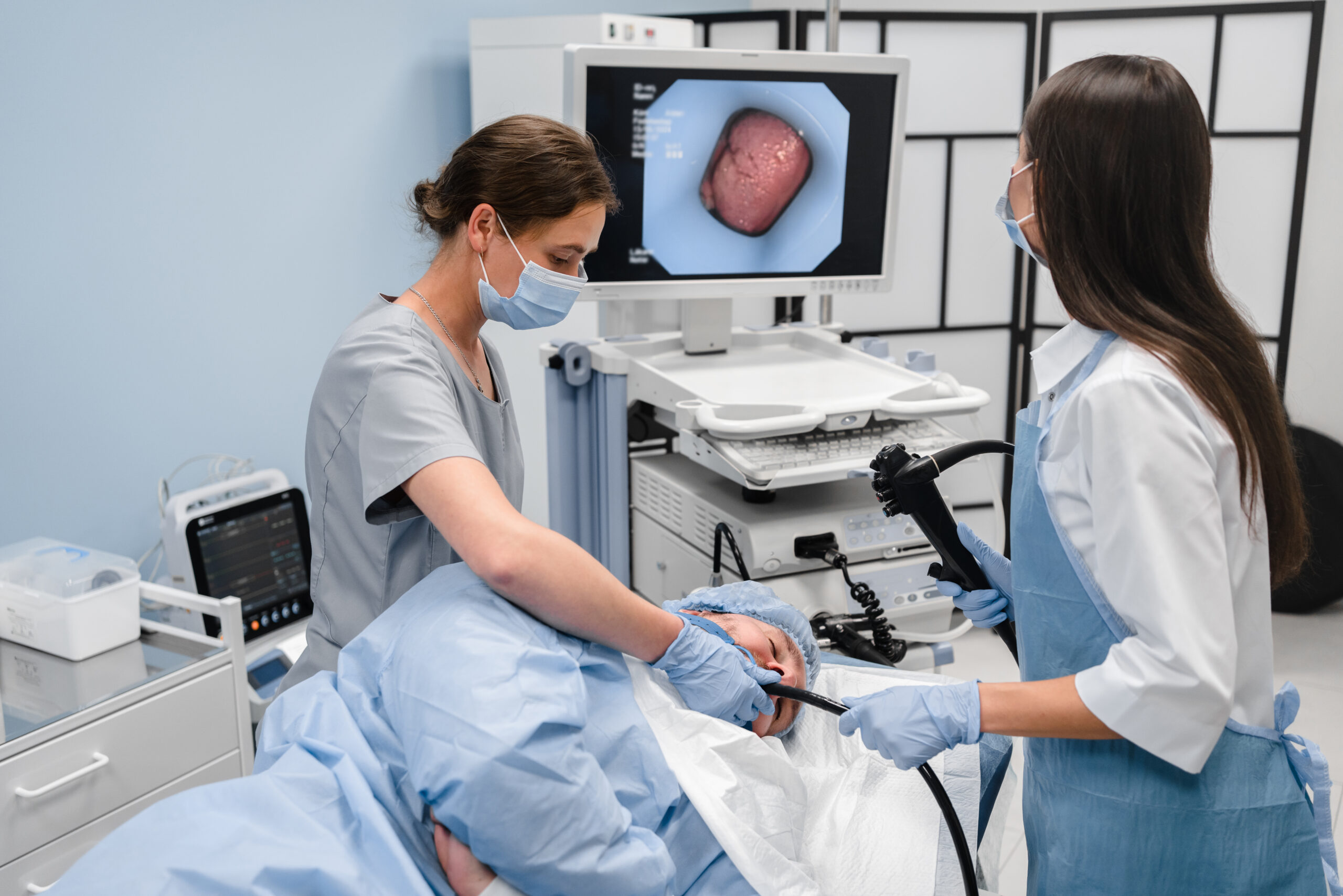 Doctor using a fiberoptic scope at gastroscopy in modern operating room.