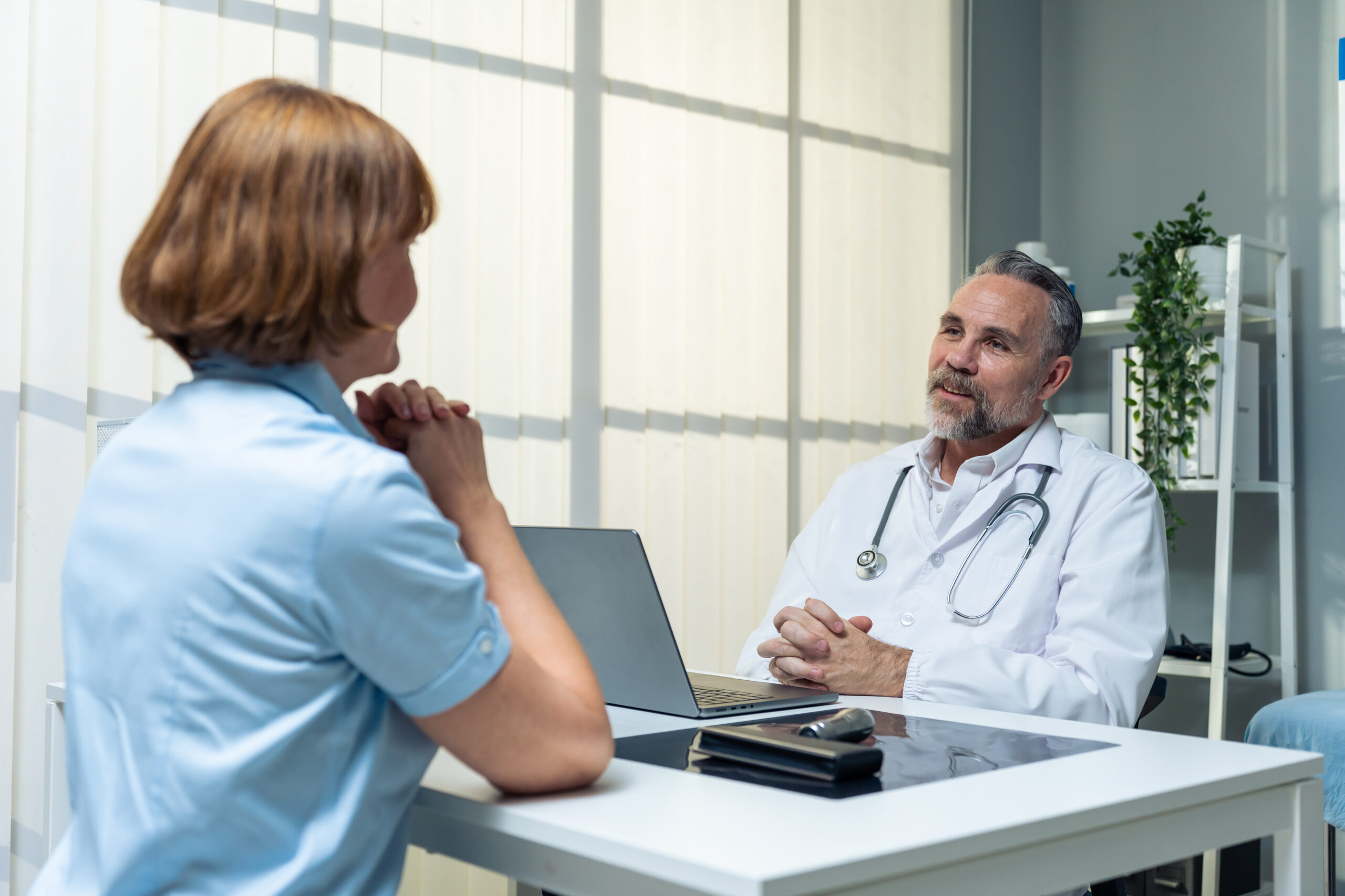doctor-and-patient-talking-at-desk-in-office-2026-03-24-23-09-08-utc