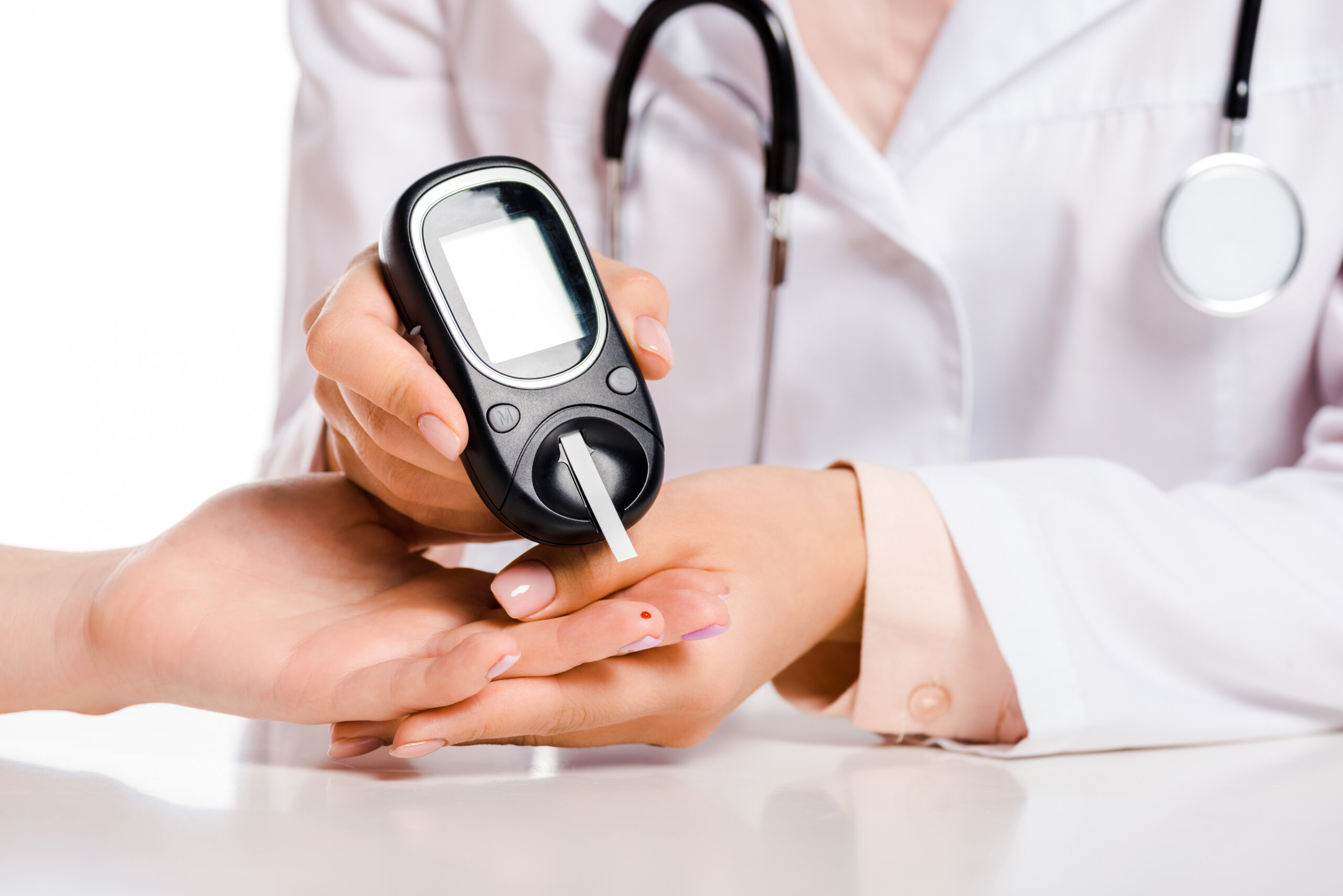 cropped image of doctor measuring patient level of glucose in blood with glucometer isolated on